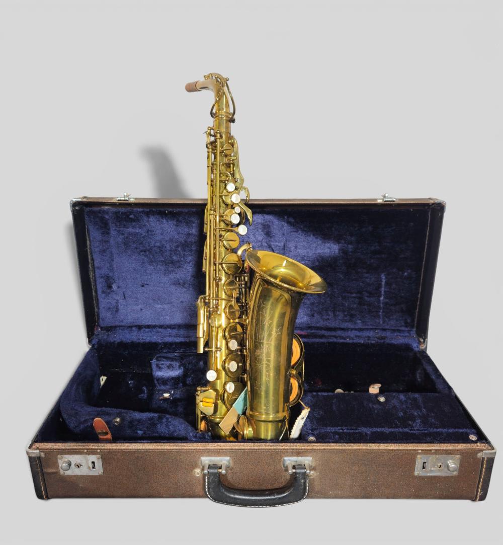 Gold alto saxophone resting upright in a blue-lined hard case with the lid open.
