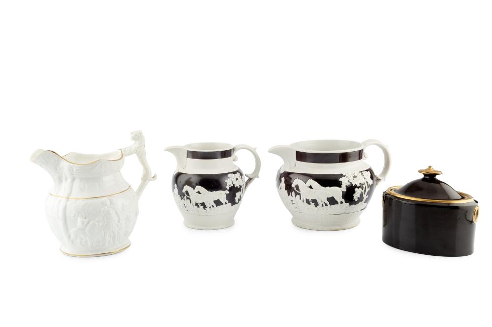 Four brown-and-white ceramic jugs and a covered sugar pot, shown side by side on a white background, with raised animal scenes on the jugs and pot.