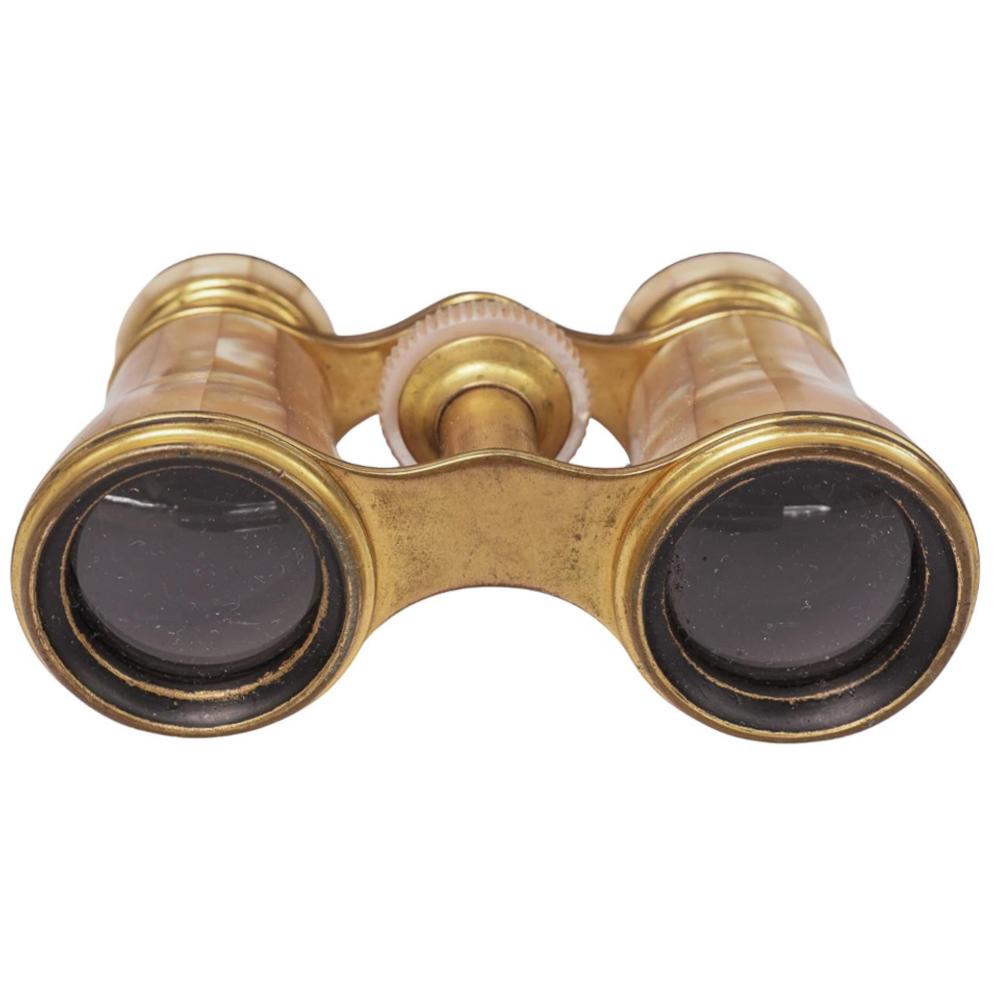 Gilded antique opera glasses with two round lenses and a central bridge, photographed against a white background.