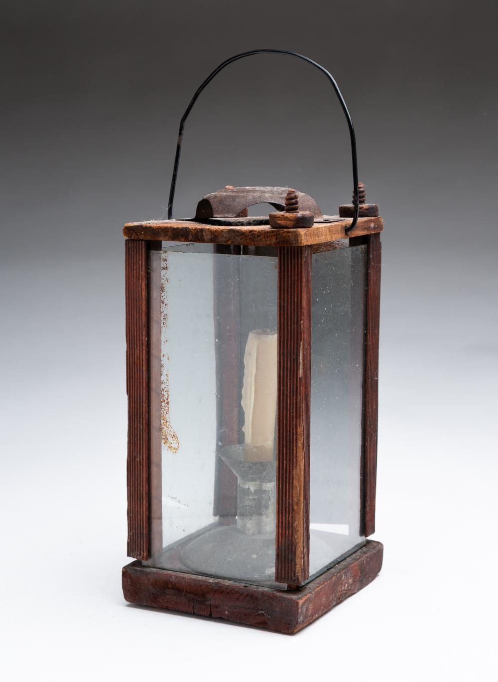 Wooden barn lantern with red-brown finish, arched handle, and clear glass panels.