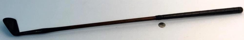 Golf club mashie with dark metal head and long shaft against a light background.