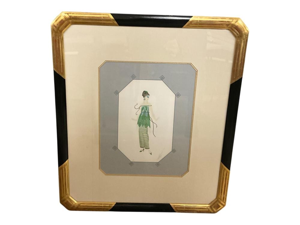 Framed art deco-style print showing a standing woman in a green patterned dress and hat against a light background.