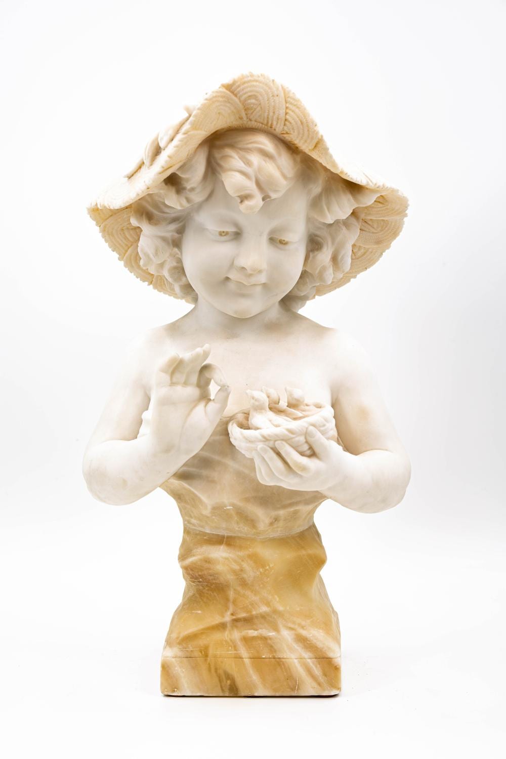 Carved child figure sculpture wearing a wide hat and holding small birds or bird chicks in its hands.