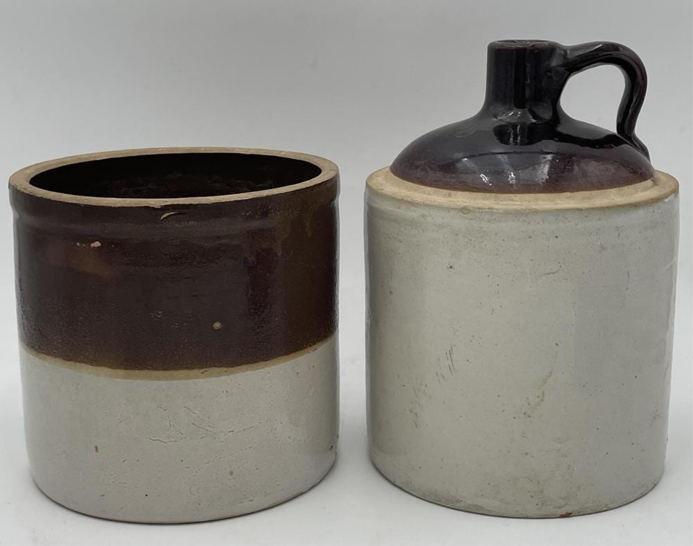 Two brown-and-white stoneware crocks or jars with wide openings, shown side by side on a white background.