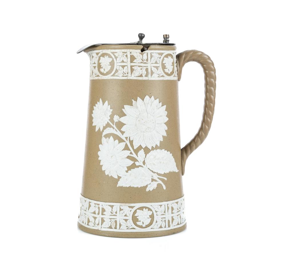 Brown and white ceramic stoneware jug with floral design and a metal lid, shown full height against a white background.