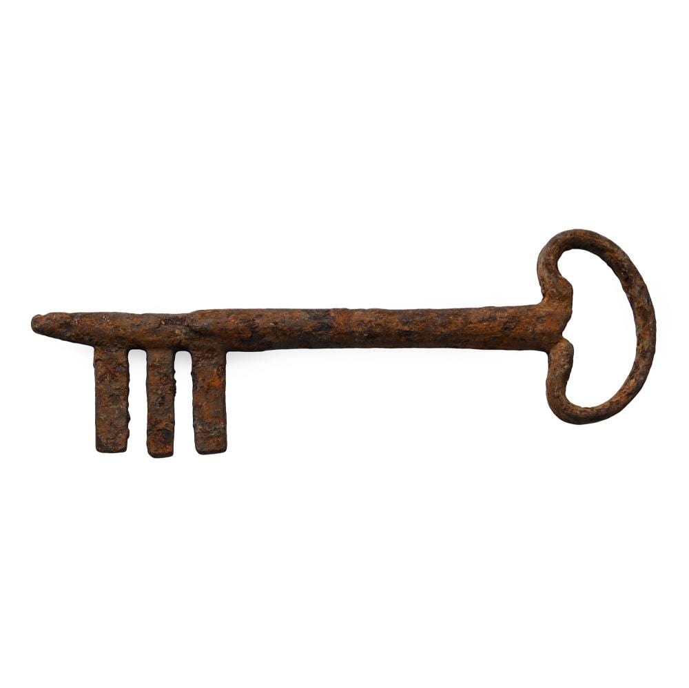 Rusty iron door key with a long bar and ring-shaped bow, shown on a plain white background.