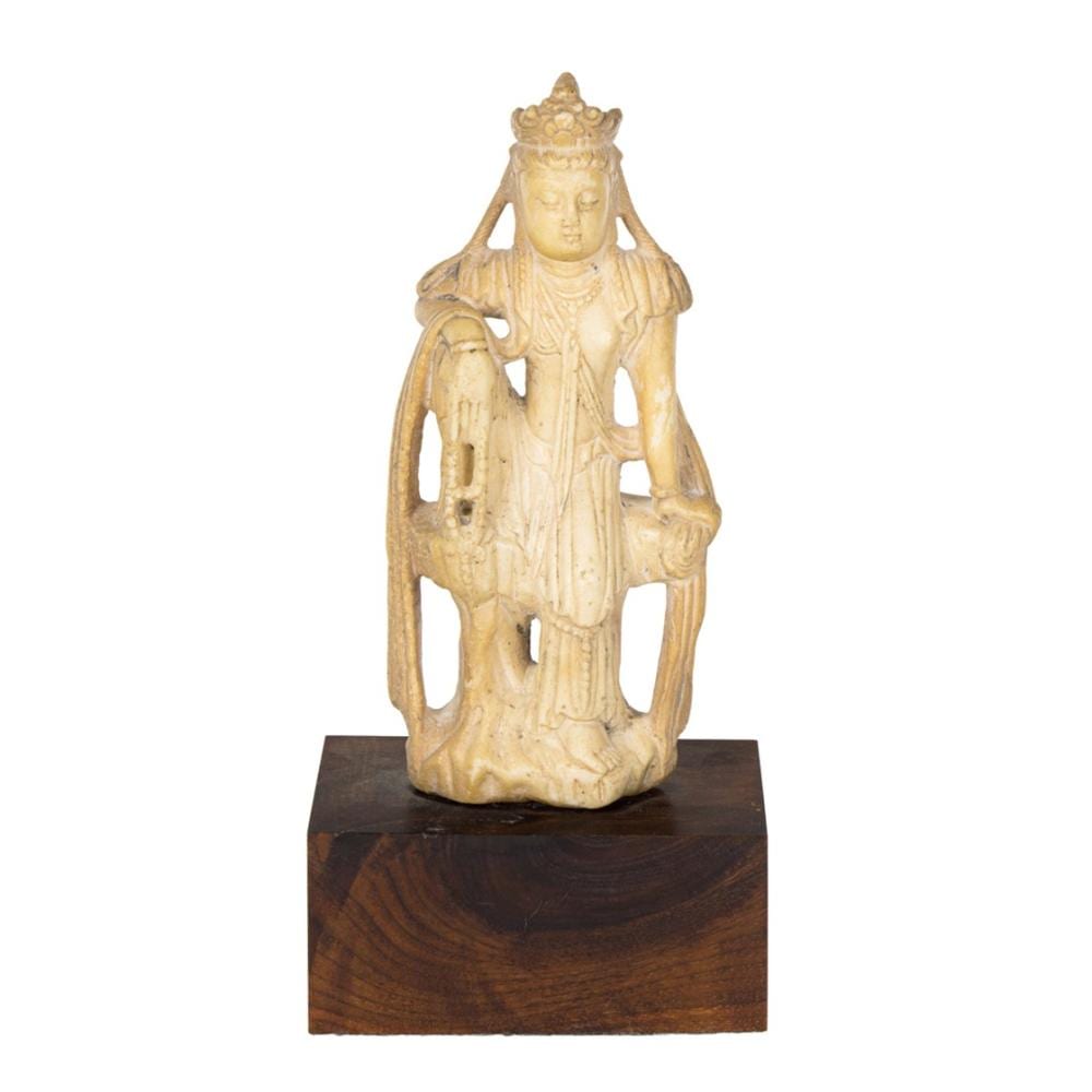 Seated gold-toned carved Buddhist deity figure with a crown and long robe, holding a small object, shown on a dark wooden base.
