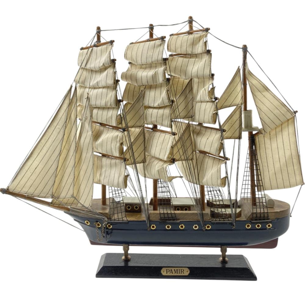 Vintage wooden model sailing ship on a dark base with beige canvas sails and blue hull
