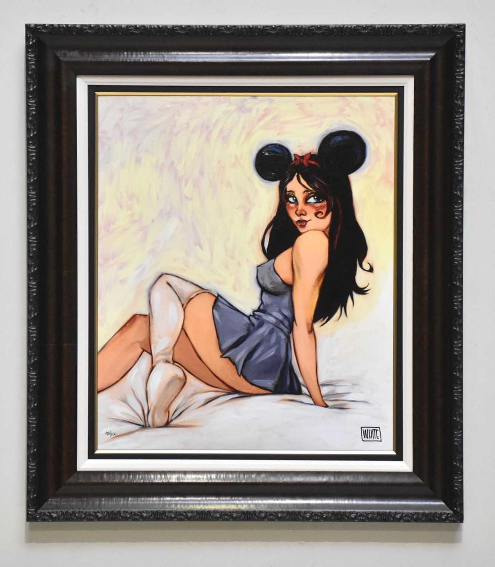 Framed pop-art style print of a seated young woman with large black mouse-like ears, reclining on bedding and looking to the left.