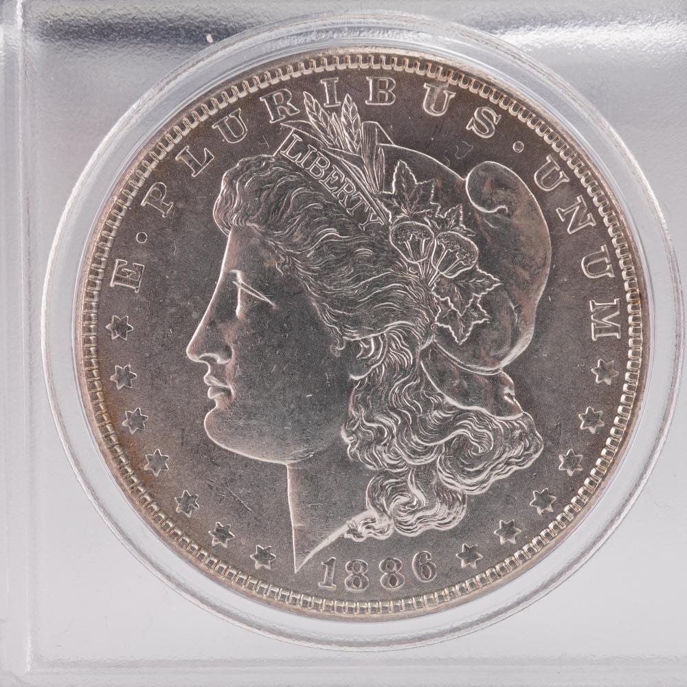 A silver coin with a portrait of Lady Liberty wearing a cap, with “LIBERTY” and “1886” visible on the face.