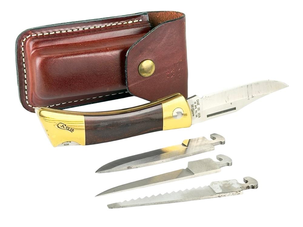 Brown leather pocket knife case with a brass-colored folding knife and three extra steel blades/attachments laid out.