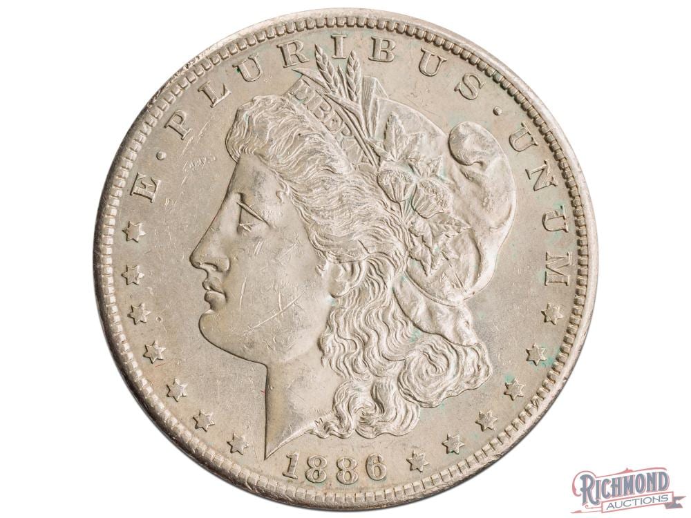 Silver-colored US one-dollar coin with a left-facing Liberty portrait, “LIBERTY” text, stars around the rim, and “1886” date.