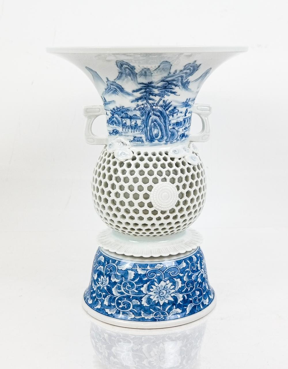 Porcelain vase with blue-and-white painted scenes and hexagonal lattice body, white rim and base, photographed on a white background.