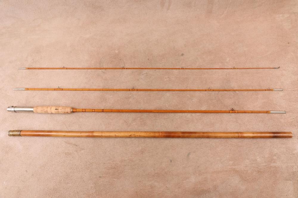 Three-piece bamboo fly fishing rod laid out horizontally, showing two thin tip sections and a longer handle section on a neutral background.