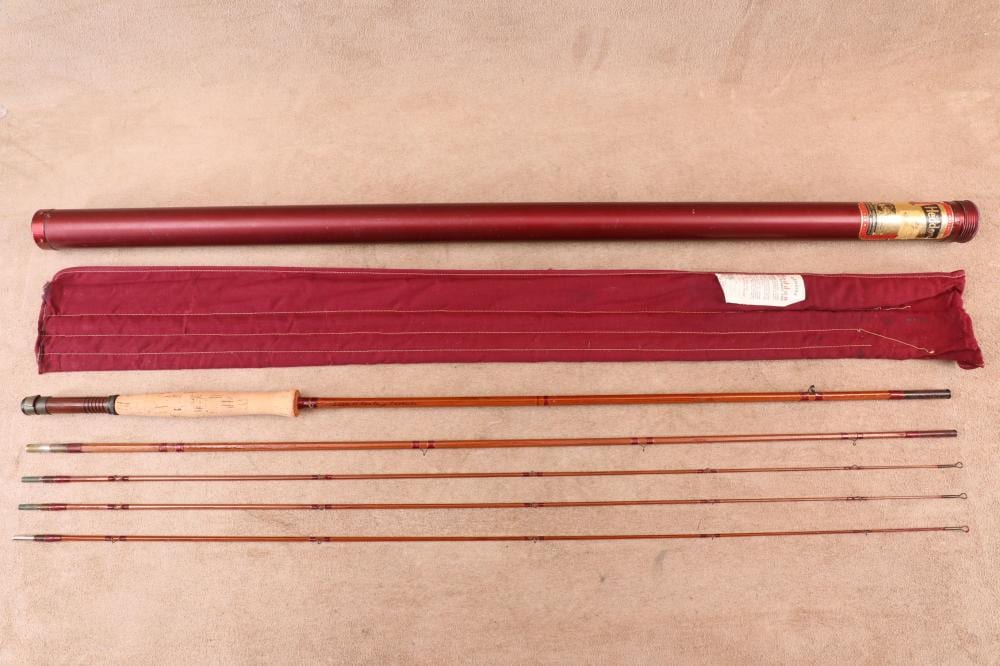 Two fishing rod sections and a closed maroon fabric rod case shown laid out on a light background.