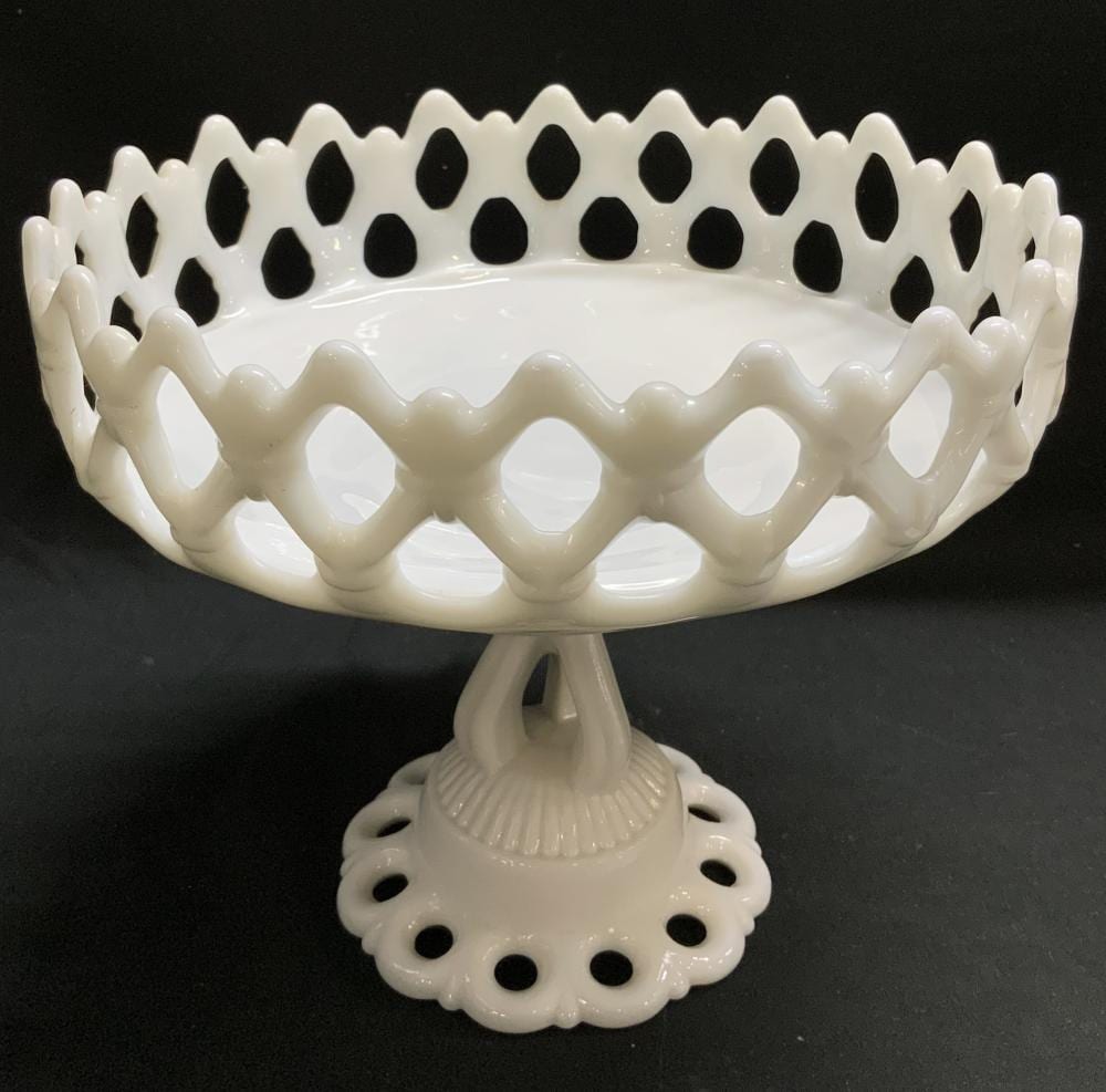 White milk glass pedestal fruit bowl with scalloped rim, raised loop handles, and a wide foot base.