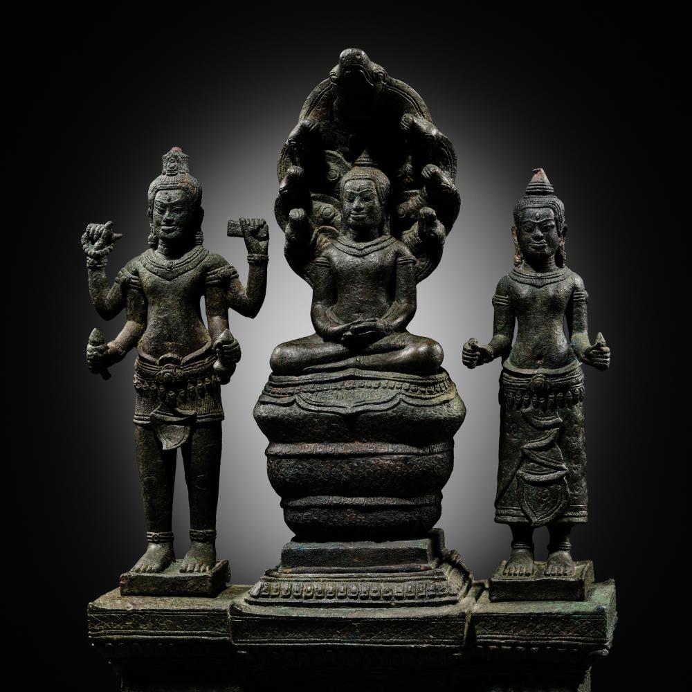 A BUDDHIST BRONZE TRIAD OF BUDDHA MUCHALINDA WITH HIS CONSORTS LOKESHVARA AND PRAJNAPARAMITA, BAYON STYLE, 13TH CENTURY sold by Galerie Zacke, lot 207 — auction record photograph