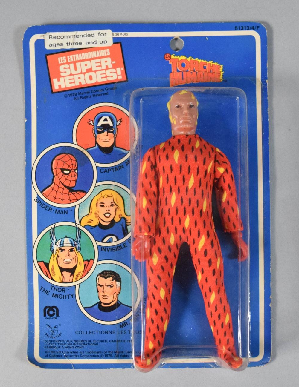 Boxed red-and-black patterned action figure in a plastic blister pack labeled Torche Humaine.