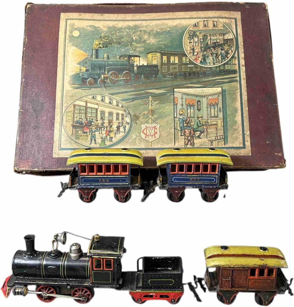 Vintage toy passenger train set with a boxed lid featuring illustrated train scenes, plus two small train cars with yellow roofs and dark blue panels.