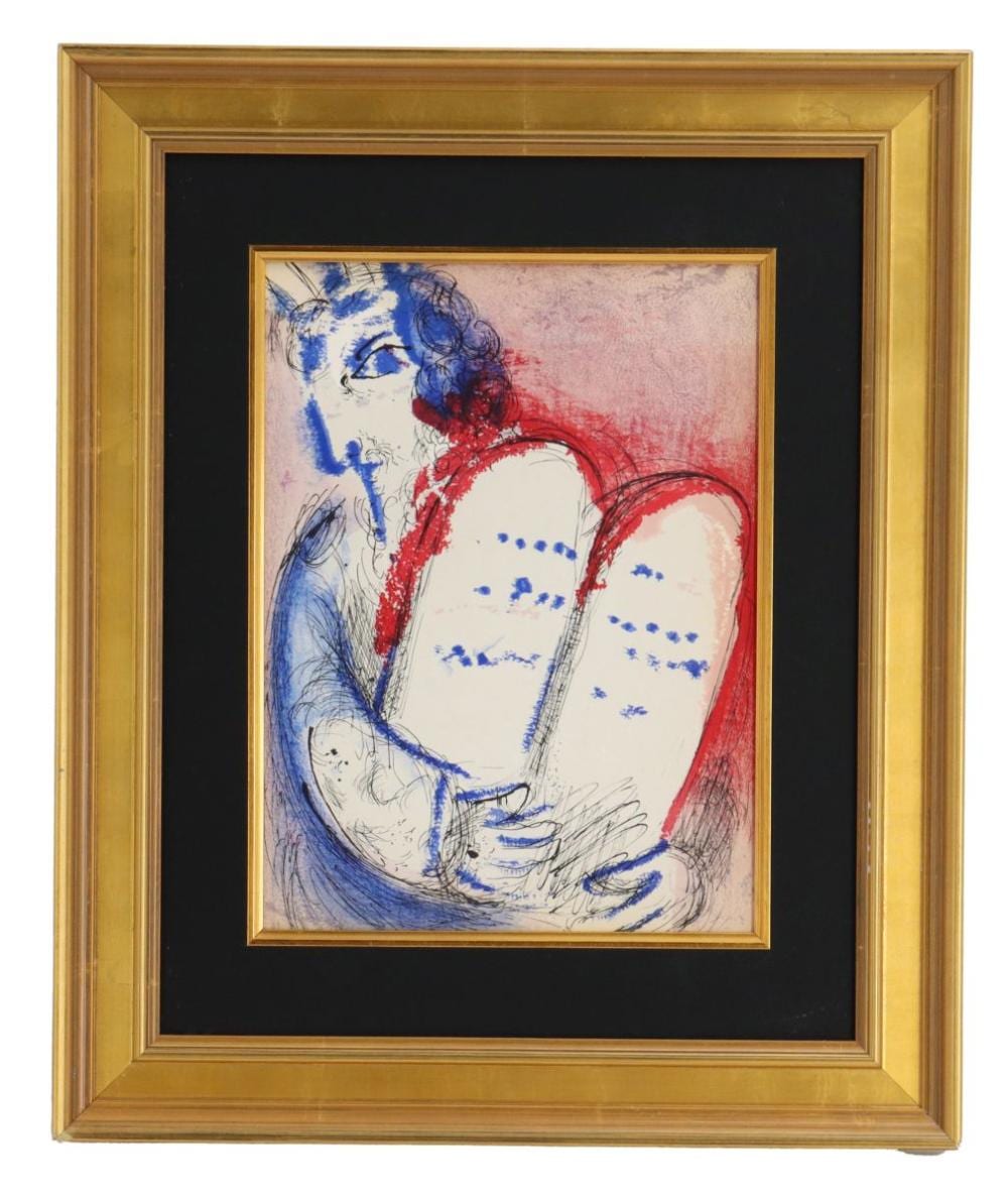Framed lithograph-style print showing a blue and red figure with long hair seated and holding a white cloth, with handwritten marks near the figure.