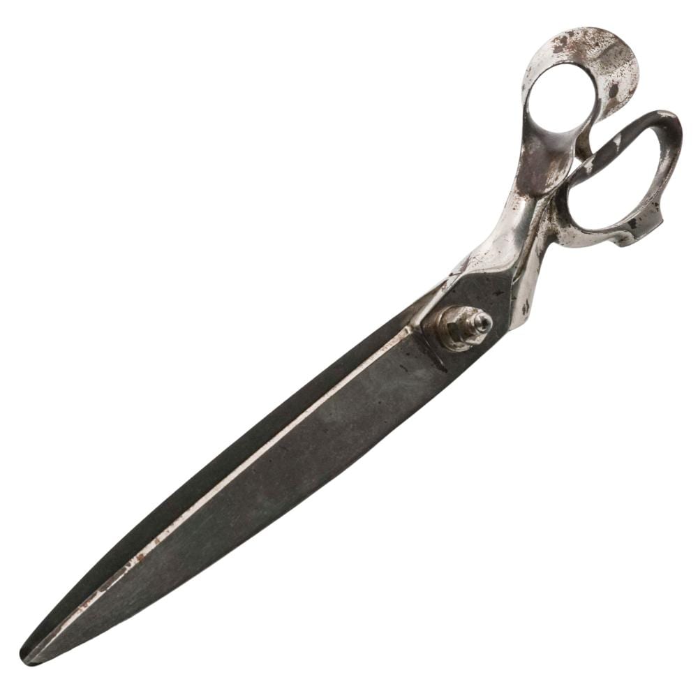 Bent pair of metal tailor’s shears with two looped finger handles on a white background.