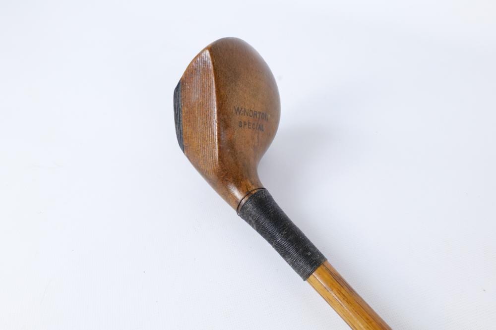 Wooden golf club head with stamped “W/norton Special” lettering and a black grip and light wood shaft against a white background.