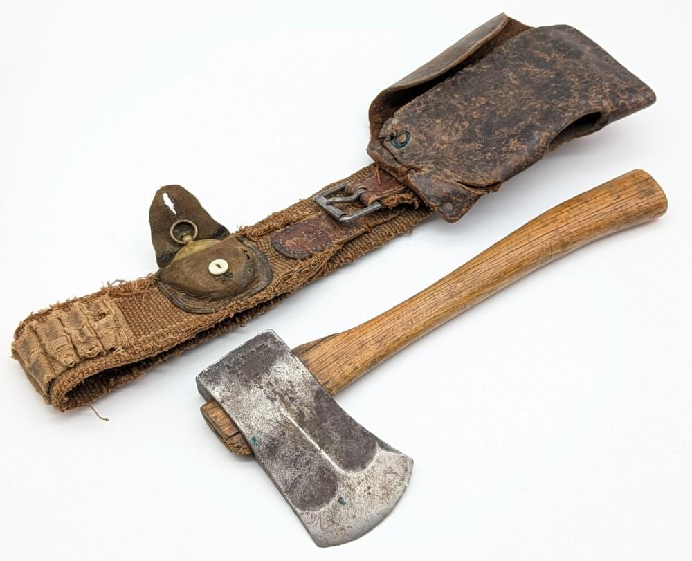 Antique-style hatchet with a wooden handle and metal blade, shown with a brown leather sheath and belt strap.