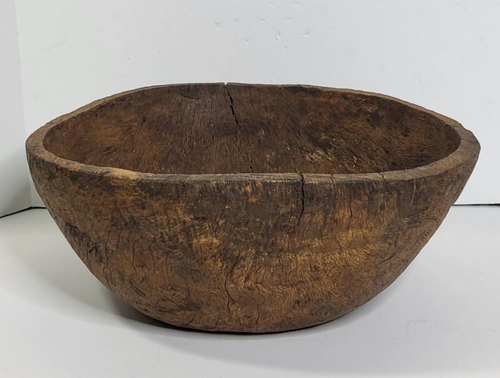 Large carved wooden bowl with a wide rim and natural grain pattern, shown on a white background.