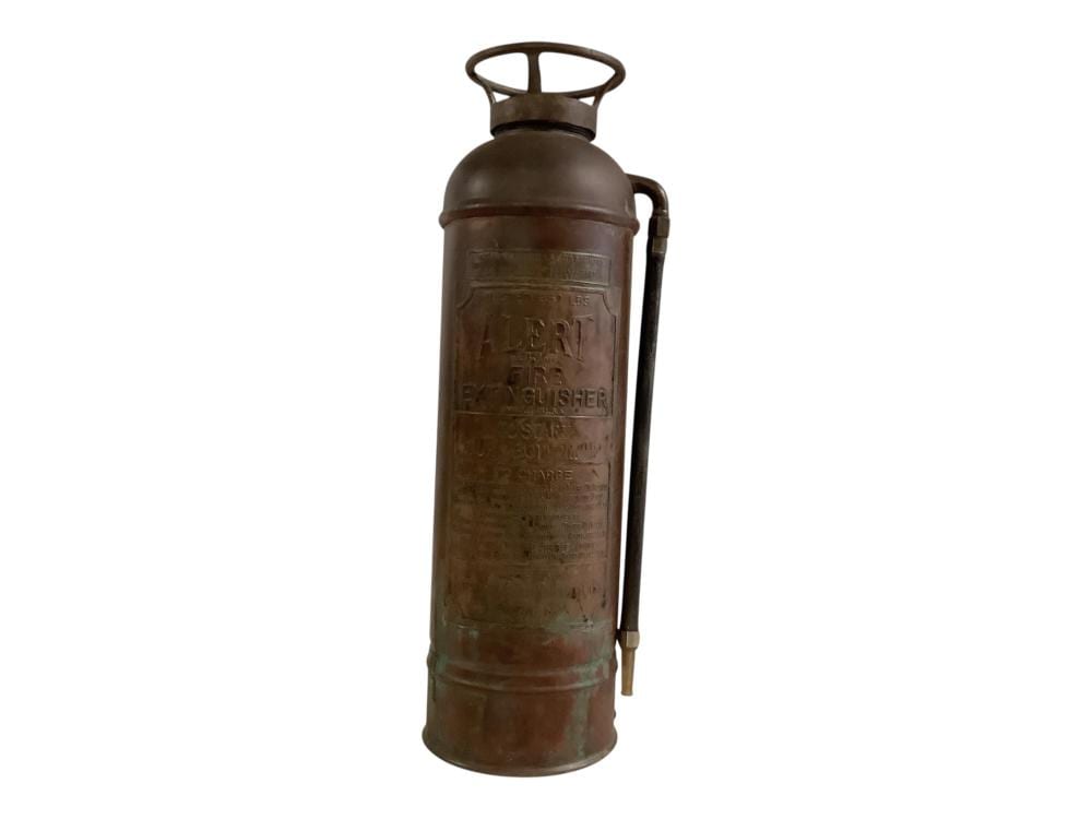 Antique-style copper fire extinguisher cylinder with a top handle and metal bracket, photographed on a white background.