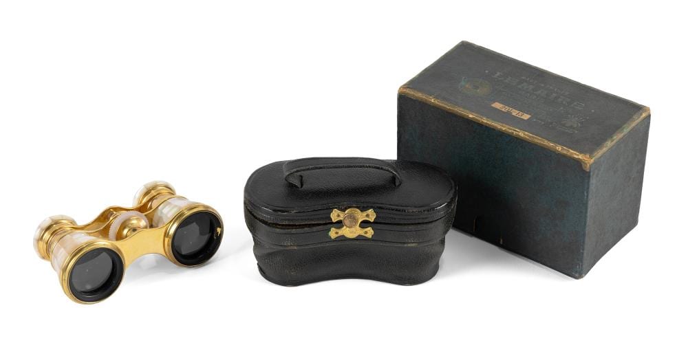 Gold-tone opera glasses with black lenses, next to a black leather case and a dark rectangular box on a white background.