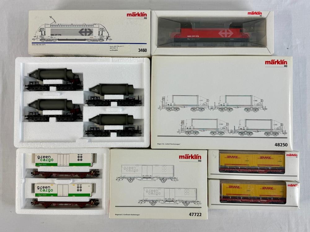 Märklin HO scale model train sets in retail boxes, showing a locomotive and freight wagons with printed diagrams.