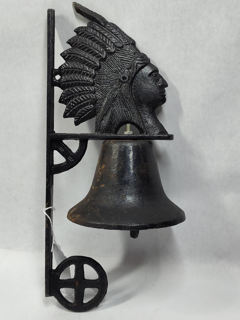 Cast iron wall-mounted dinner bell with an embossed Native American-style chief figure and a hanging bell.