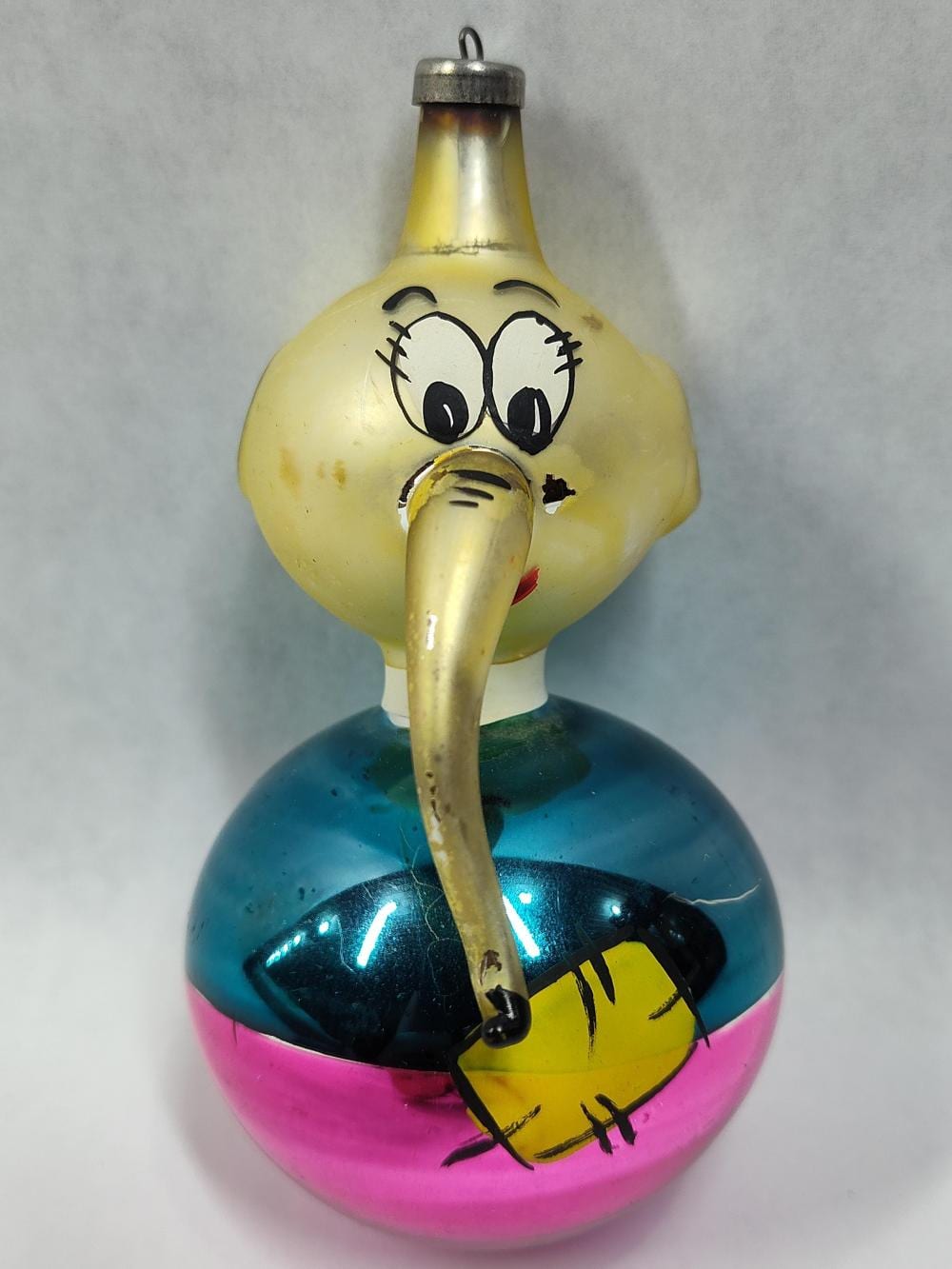 Mid-century hand-blown glass character Christmas ornament shaped like a yellow duck with big cartoon eyes, a beak, and a hanging cap.