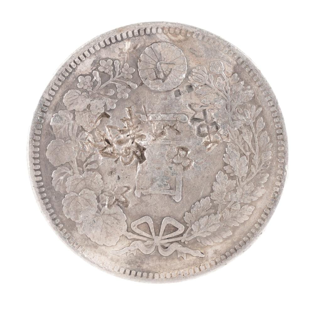 Silver-colored Japanese coin with floral and chrysanthemum motifs, shown front-on with a circular rim of small marks.
