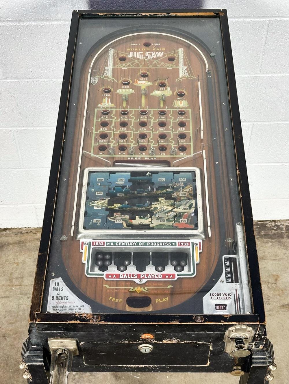 Front view of a vintage pinball machine with an arched playfield labeled "WORLD'S FAIR" and "FREE PLAY" plus score and ball controls.