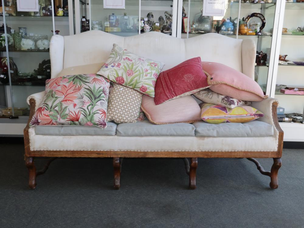 ANTIQUE OAK FRAMED THREE SEATER SHABBY CHIC COUCH WITH WHITE UPHOLSTERY AND A SELECTION OF FLORAL THROW CUSHIONS, NOTE STAINS AND DAMAGE TO UPHOLSTERY sold by Albion Antique Auction Centre, lot 1126 — auction record photograph