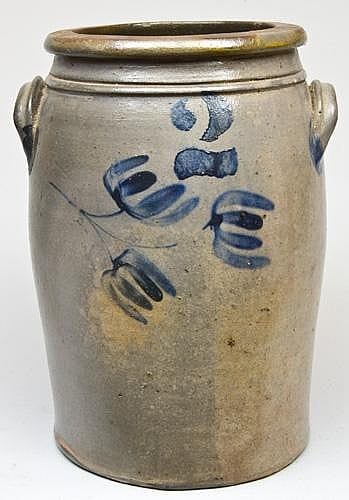 Stoneware crock with a short neck and two side loop handles, painted with blue floral and hand-like motifs.