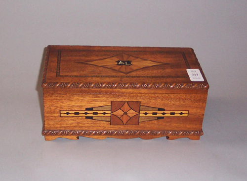 Small wooden jewelry box with geometric inlaid decorations on the lid and sides.