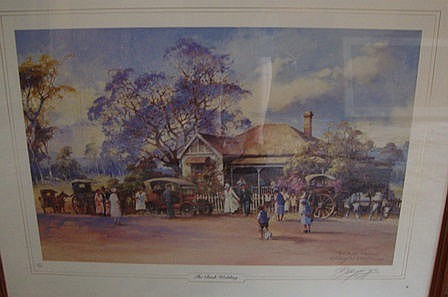 Framed signed print showing a rural street scene with people walking, horses and wagons, and trees in the background.