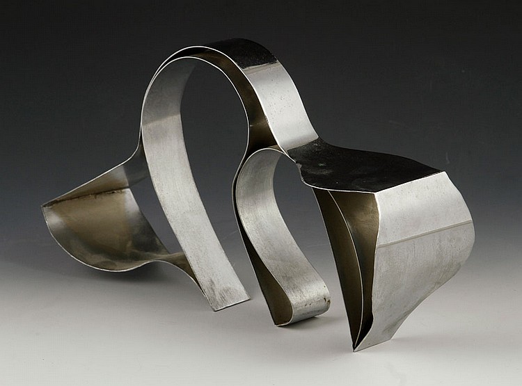 Metal cat sculpture with curled ribbon-like body and ears, shown in a studio against a dark background.