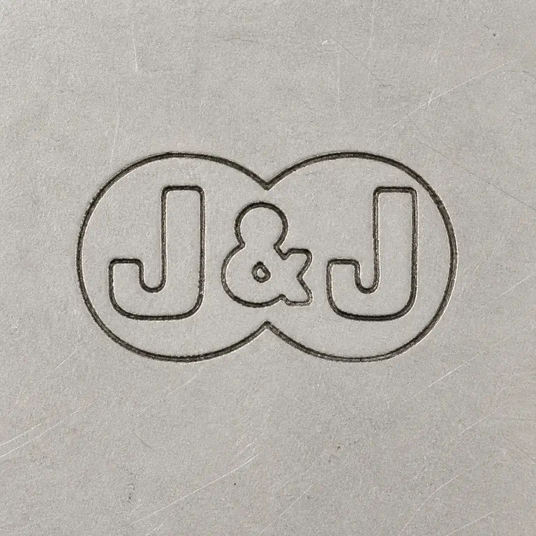J & J: J, ampersand-like separator, and J arranged left to right inside one compact horizontal oval-like cartouche; oxidized reconstruction.