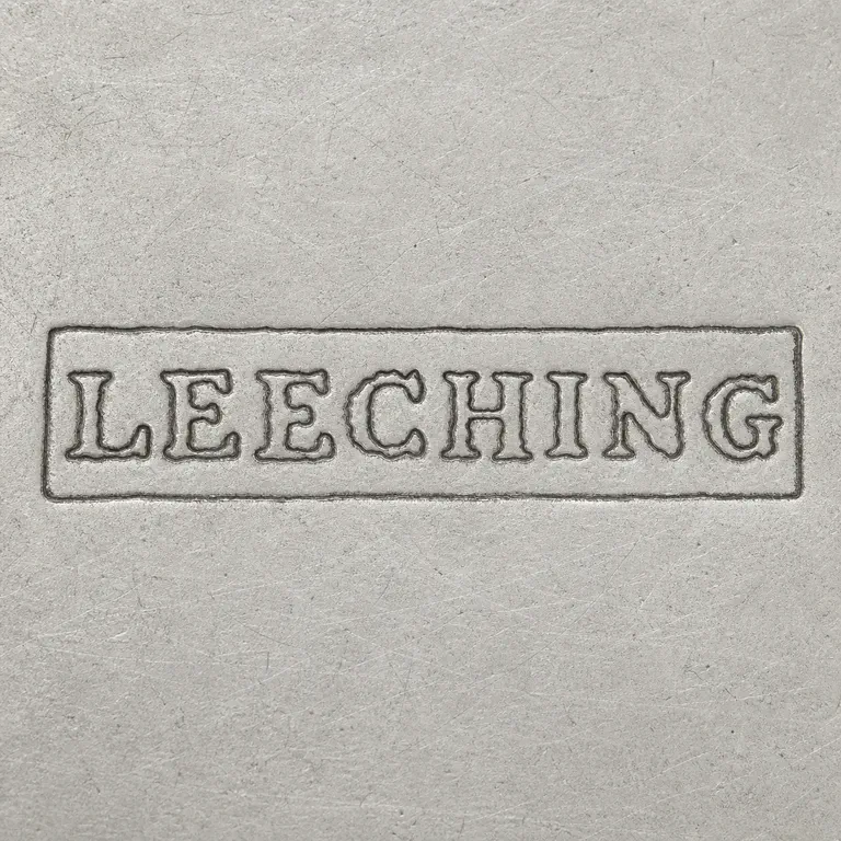 SILVERSMITH: Uppercase LEECHING inside exactly one long rectangular enclosure, photographic crop edge removed; oxidized reconstruction.
