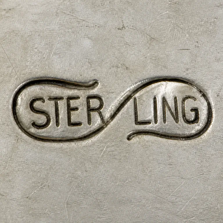 Scharling & Co.: Uppercase STERLING split as STER and LING within a single horizontal infinity-like two-lobed outline; oxidized reconstruction.