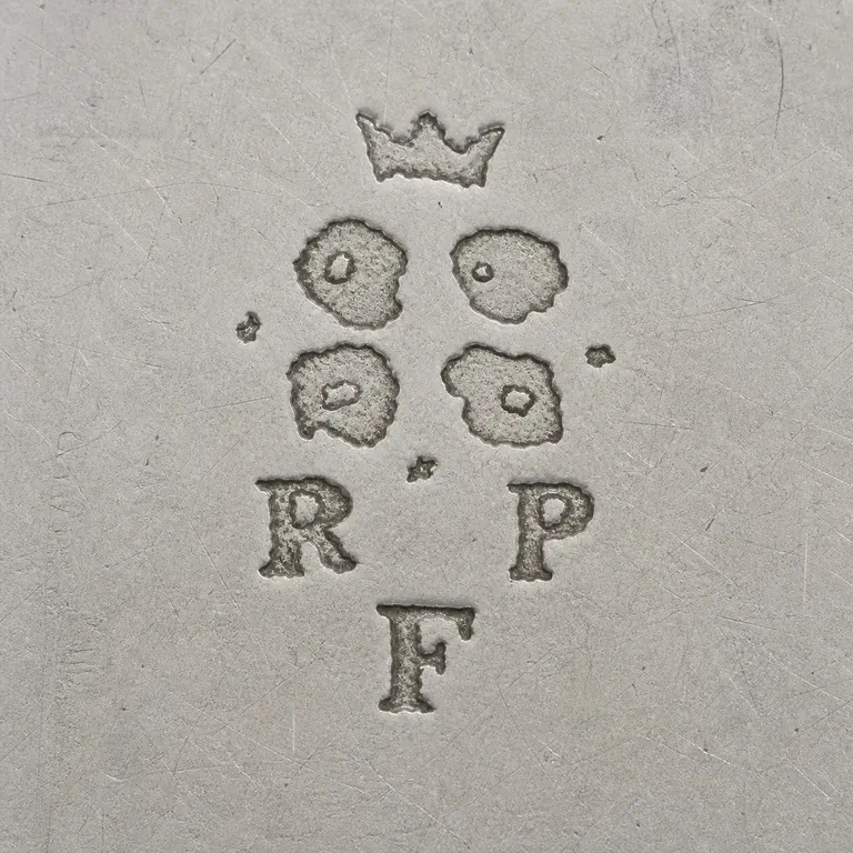 Rudolphe Beunke: Sparse unbordered group with crown-like upper fragment, four separate worn circular lobes, R and P on the lower row, F below, and tiny de…; oxidized reconstruction.
