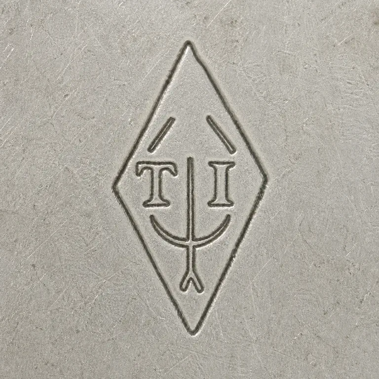 Tallois & Mayence: Vertical diamond with T at left, I at right, two upper diagonal fragments, a narrow central stem, shallow lower crescent, and forked bottom; oxidized reconstruction.
