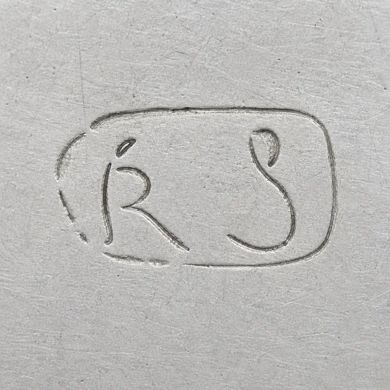 R S: R/S-like curved forms worn compact boundary are retained without a confirmed transcription; oxidized reconstruction.