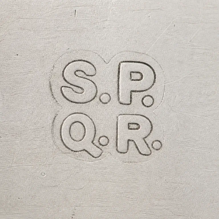 S P over Q R: Four-part S/P over Q/R arrangement, dots, rounded interlocking layout, and vertical order; oxidized reconstruction.