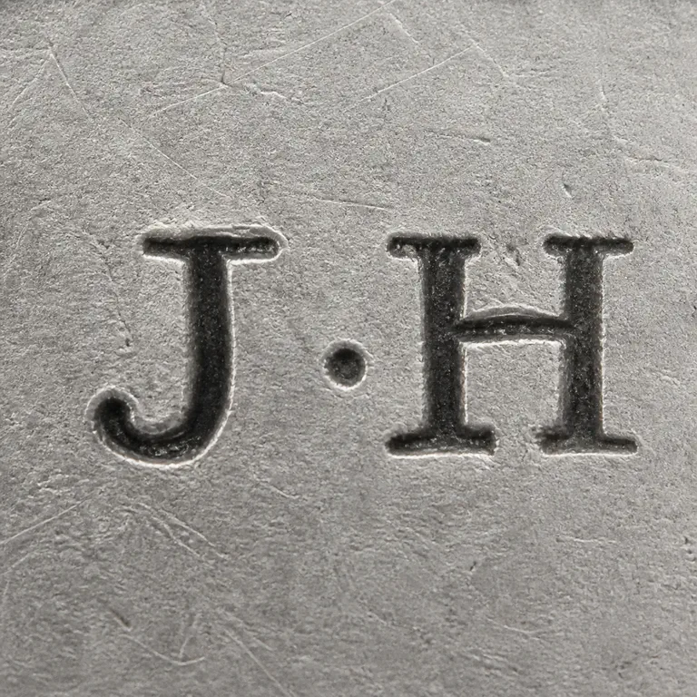 James Heales: The J, central separator dot, and H forms same spacing and orientation; oxidized reconstruction.