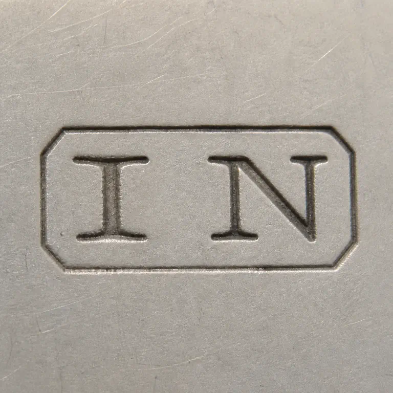 Joseph Nowill: JN as two uppercase serif capitals without punctuation, centered inside one compact horizontal rectangular cartouche; oxidized reconstruction.