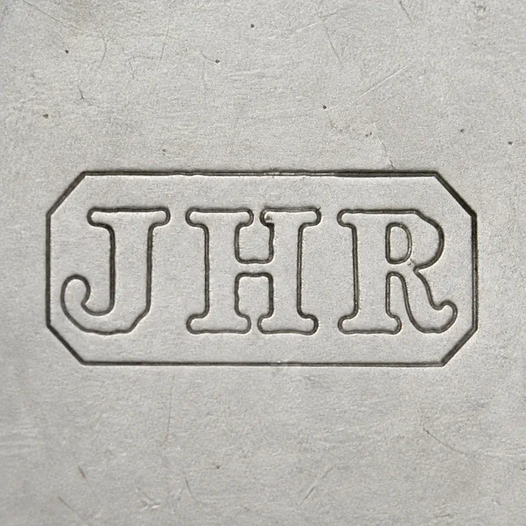 John Henry Rawlings: JHR compact chamfered plaque in source order; oxidized reconstruction.